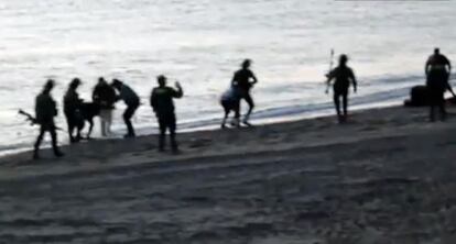 Civil Guard officers returning migrants to Morocco at Tarajal beach.