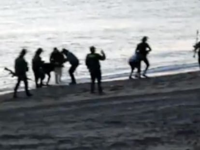 Los guardias civiles devuelven a inmigrantes a Marruecos en la playa deTarajal.