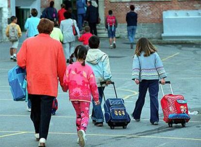 Varios niños y padres acuden a un centro escolar en Vitoria al comenzar el curso.