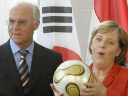 Angela Merkel junto al presidente del comité organizador de la Copa del Mundo de Fútbol de 2006, Franz Beckenbauer, en una imagen de archivo.