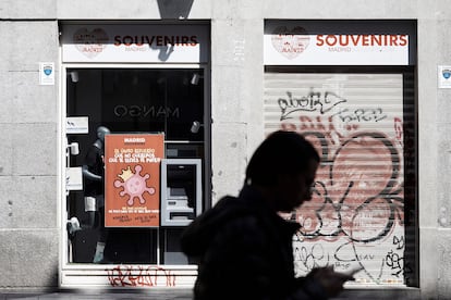 Una persona pasa delante de establecimientos cerrados en Madrid durante el estado de alarma.