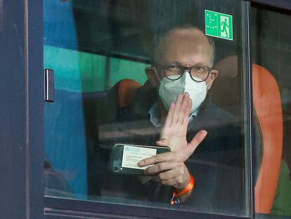 Uno de los investigadores de la OMS saluda desde el autobús de camino al hotel donde guardarán cuarentena.
