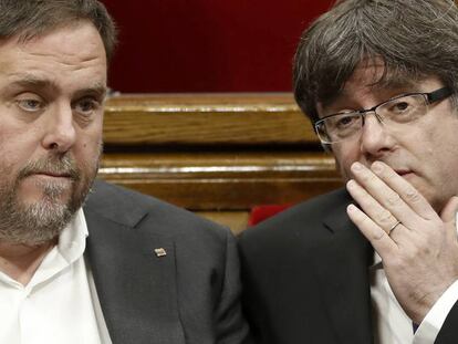 El presidente de la Generalitat, Carles Puigdemont, habla con el vicepresidente, Oriol Junqueras.