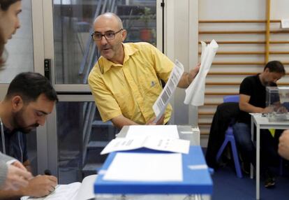 Un funcionari de Correus lliura el vot emès per correu a l'Escola Mireia de Barcelona.