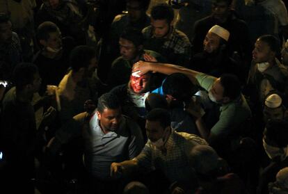Un herido durante los enfrentamientos es ayudado por sus compañeros en El Cairo, 15 de julio de 2013.