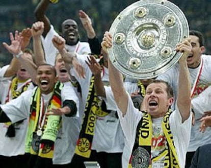 Los jugadores del Borussia de Dortmund celebran el título, con su capitán Stefan Reuter, quien levanta el trofeo de la Bundesliga.