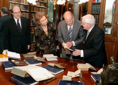 Los Reyes de España acompañados del ministro de Educación Ángel Gabilondo atienden a la explicaciones del director de la Real Academia Española, Víctor García de la Concha.