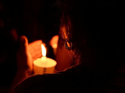 Una mujer enciende una vela durante la vigilia por los fallecidos en el tiroteo masivo en una iglesia bautista en Sutherland Springs, Texas.