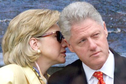 La secretaria de Estado estadounidense, Hillary Clinton, susurra al oído de su marido, el ex presidente Bill Clinton.
