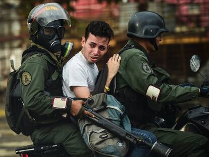 Un activista anti-gobierno es arrestado durante los enfrentamientos en Caracas el 28 de julio de 2017.