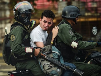 Un activista anti-gobierno es arrestado durante los enfrentamientos en Caracas el 28 de julio de 2017.