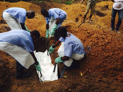 Varios voluntarios entierran el cadáver de un contafiado por ébola en Kailahun, Sierra Leona