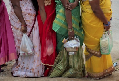 Devotas hindúes esperan con sus ofrendas a la entrada de un templo durante la festividad de Nag Panchami, celebrado en Hyderabad (.India).