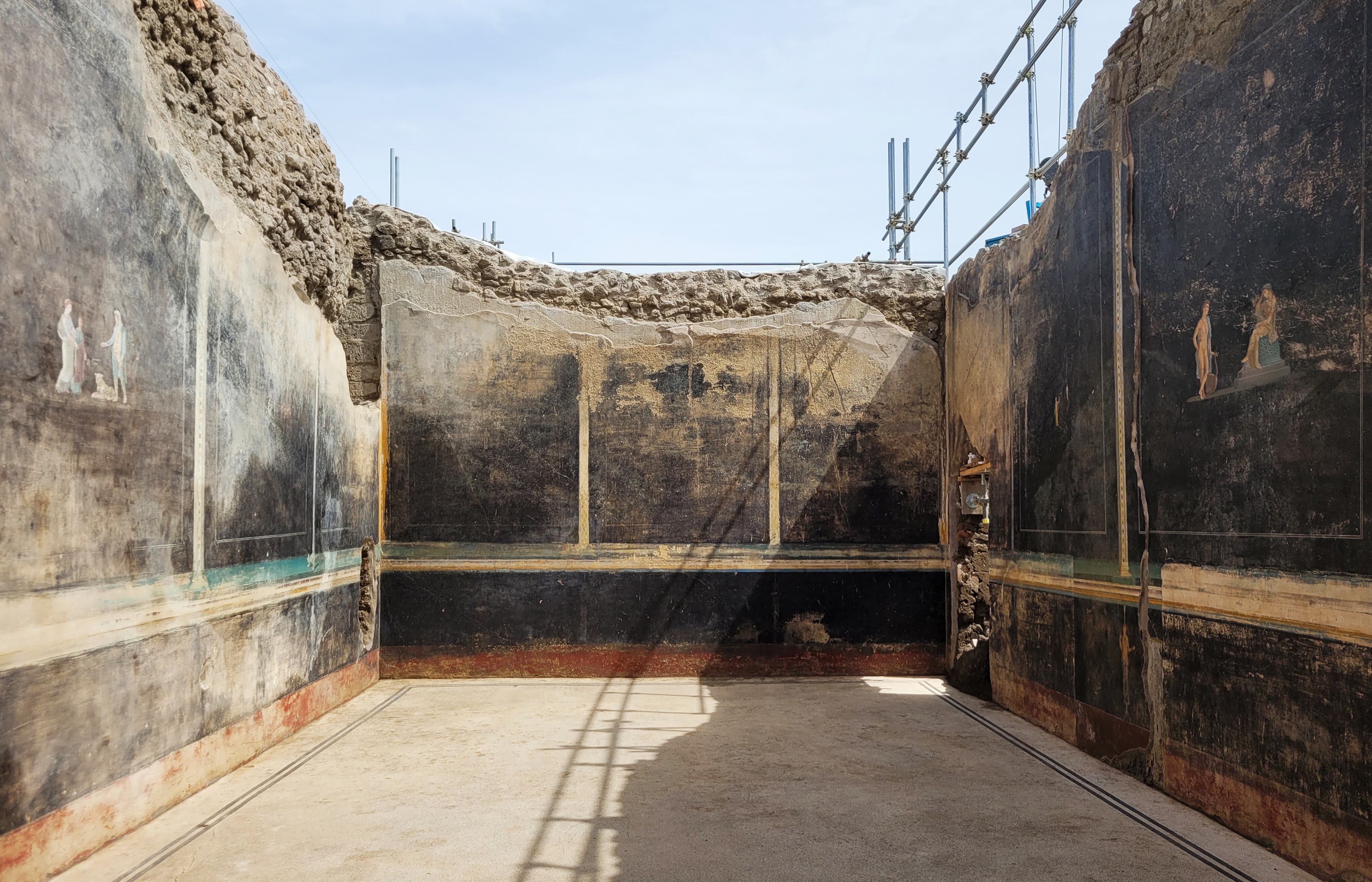 Descubrimiento de un imponente salón de banquetes, de elegantes paredes negras y decorado con frescos con temas mitológicos inspirados en la guerra de Troya. 