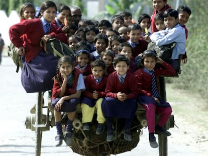 Más de 35 niños vuelven de la escuela subidos en un carro en las afueras de Nueva Delhi.