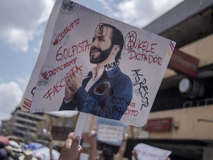 Un manifestante levanta una pancarta en contra del presidente de El Salvador, Nayib Bukele
