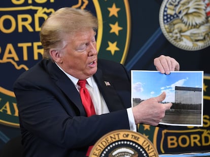 Trump muestra una foto del nuevo muro, este martes en Yuma, Arizona.