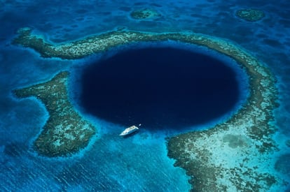 Las paredes verticales del monumento natural Blue Hole (Gran Agujero Azul), en Belice, descienden más de 120 metros hacia el fondo del océano, creando una perfecta circunferencia de intenso azul. Su interior alberga un denso bosque de estalactitas y estalagmitas, así como grupos de tiburones de arrecife.