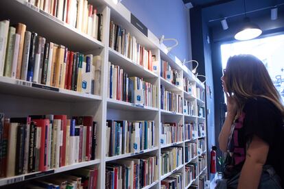 Una mujer revisa una estantería en una librería en Madrid.
