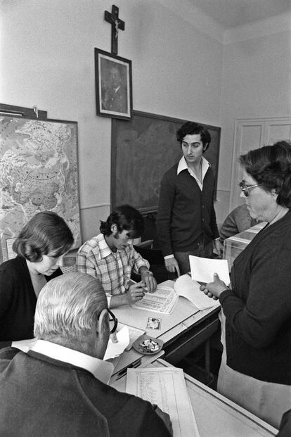 Una mujer deposita su voto en la mesa de un colegio de Madrid en las elecciones legislativas del 15 de junio de 1977, las primeras democráticas en España tras el franquismo. Presidiendo el aula, un crucifijo y el retrato de Franco.