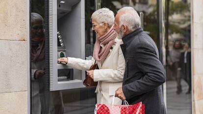 Una pareja de ancianos utiliza un cajero automático.