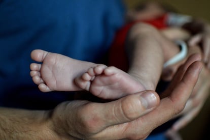 Un hombre sostiene a su bebé de un mes, en una imagen de archivo.