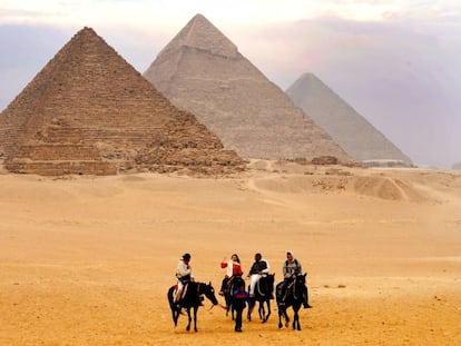 Turistas frente a las tres pirámides de Guiza.