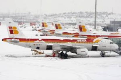 Aviones de Iberia, cubiertos de nieve en la T-4 del aeropuerto de Barajas. EFE/Archivo