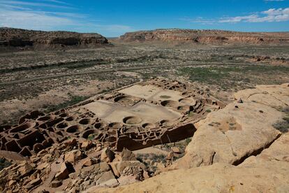 A hiker sits on a ledge above Pueblo Bonito, the largest archeological site at the Chaco Culture National Historical Park, in northwestern New Mexico