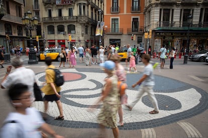 Varias personas caminan por el mosaico de Miró, dibujado en el punto exacto donde la furgoneta de los terroristas se detuvo tras atropellar a la multitud aquel fatídico 17 de agosto de 2017 en La Rambla.