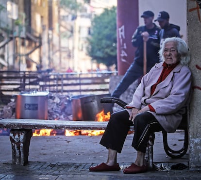 Una mujer espera frente a residentes que cocinan una olla popular durante la cuarentena en Buenos Aires.