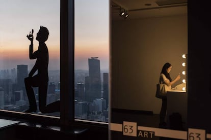 Una mujer se hace una fotografía en un espejo del rascacielos 63 City de Seúl (Corea del Sur).