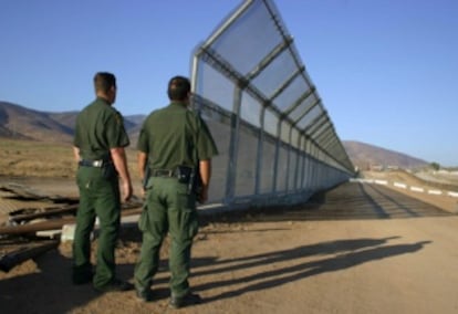 Dos policías vigilan la frontera de México con EE UU.