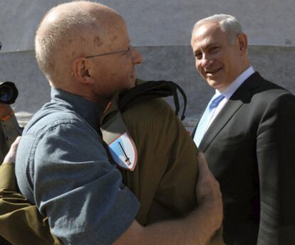 El primer ministro israelí, Benjamín Netanyahu, observa el abrazo entre Noam y Gilad Shalit, padre e hijo, tras la liberación de este.