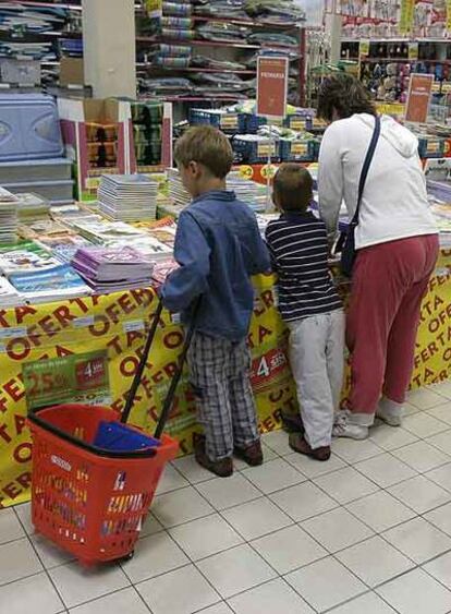 Una familia mira libros de texto en una superficie comercial.