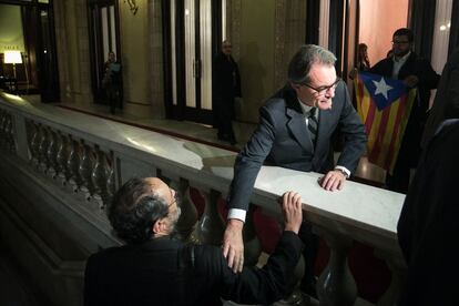 Antonio Baños, de espaldas, y Artur Mas se saludan tras finalizar el debate de investidura.