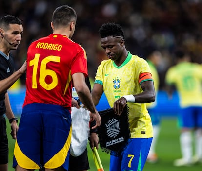 Rodrigo y Vinícius Junior intercambian los banderines antes del partido.