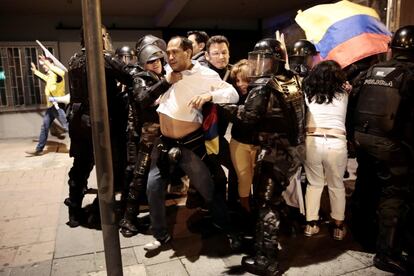 Policías ecuatorianos detienen a simpatizantes del candidato centroderechista a la presidencia de Ecuador, Guillermo Lasso, en Quito.