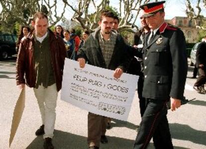 Dos manifestantes llevan un billete ficticio para que el consejero de Medio Ambiente vaya a manifestarse a Madrid.