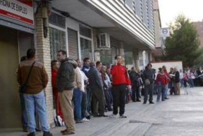 Decenas de personas esperan su turno ante una oficina del Instituto Nacional de Empleo (INEM) en el madrileño barrio de Santa Eugenia. EFE/Archivo
