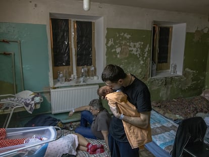 Un padre besa a su bebé recién nacido, en el sótano de una maternidad que se utiliza como refugio antibombas, durante una alerta de ataque aéreo, el martes en Kiev, Ucrania.