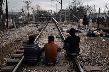 Migrantes se sientan en las vías del tren, frente a la frontera de Grecia y Macedonia, en la localidad griega de Idomeni.