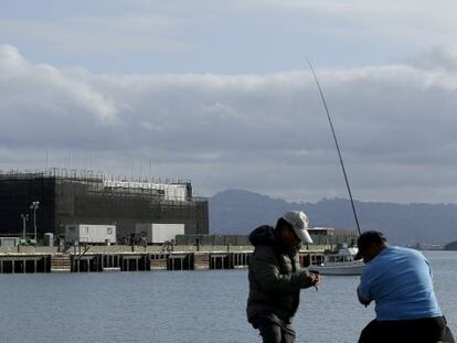 Dos hombres pescan frente a la misteriosa barcaza construida en la bah&iacute;a de San Francisco.