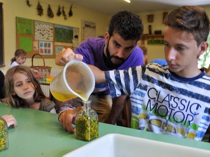 Roger Duato, educador ambiental, ayuda a una niña a elaborar un frasco aromático en una actividad para todas las familias. 