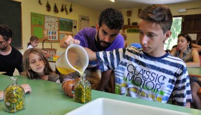 Roger Duato, educador ambiental, ayuda a una niña a elaborar un frasco aromático en una actividad para todas las familias.