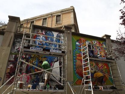 Dos artistas gr&aacute;ficos pintan los muros externos del espacio autogestionado de Tabacalera. 