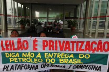 Un grupo de manifestantes fue registrado este jueves al sostener una pancarta, durante la ocupación de la sede del ministerio de Minas y Energía de Brasil en Brasilia, para exigir que se suspenda la licitación del mayor yacimiento de petróleo del país, prevista para el próximo lunes.