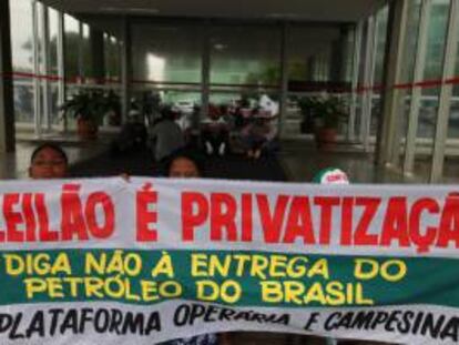 Un grupo de manifestantes fue registrado este jueves al sostener una pancarta, durante la ocupación de la sede del ministerio de Minas y Energía de Brasil en Brasilia, para exigir que se suspenda la licitación del mayor yacimiento de petróleo del país, prevista para el próximo lunes.