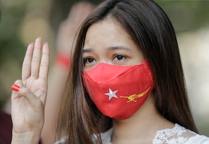 Manifestante com máscara do partido de Aung San Suu Kyi, no protesto deste sábado contra a junta militar em Yangon.