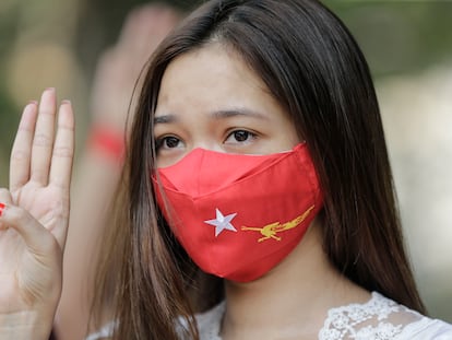 Manifestante com máscara do partido de Aung San Suu Kyi, no protesto deste sábado contra a junta militar em Yangon.